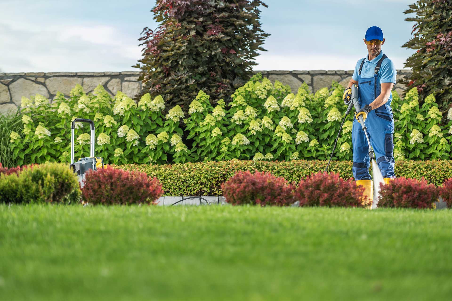 Garden Keeper Cleaning Residential Driveway Using Pressure Washe